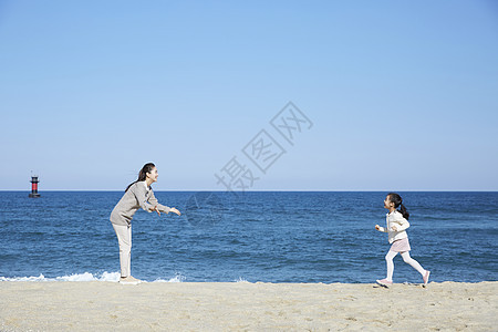 海边沙滩上小女孩跑向妈妈图片