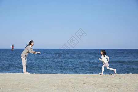 海边沙滩上小女孩跑向妈妈图片
