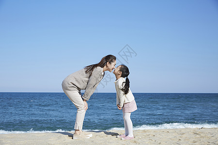 亲吻母亲女儿假期海边的母女旅行亲吻对方背景