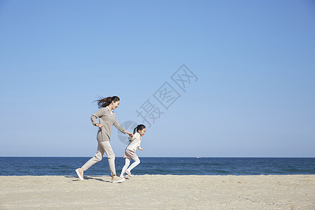 母女在沙滩上奔跑图片