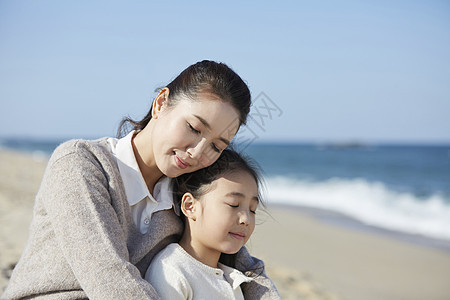 海边沙摊上母女抱在一起图片