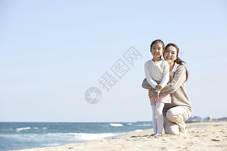 海边沙摊上母女抱在一起图片