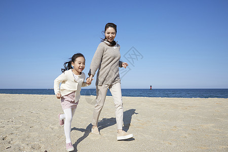 母女在沙滩上奔跑图片