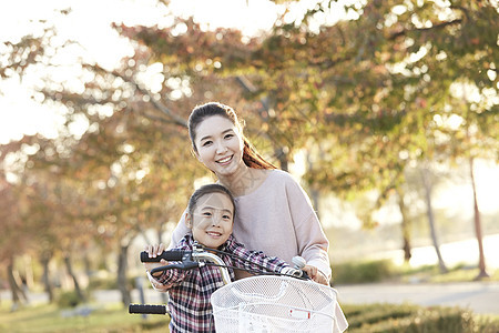 母女骑行双人自行车游览公园图片