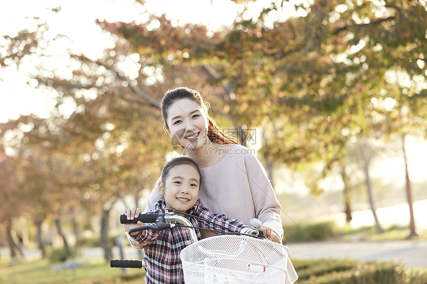 母女骑行双人自行车游览公园图片