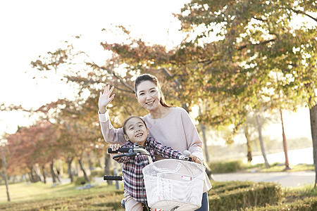 母女骑行双人自行车游览公园图片