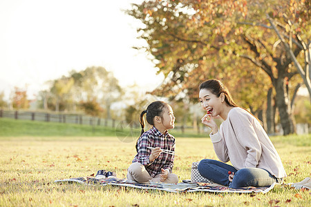户外的秋天女孩母亲女儿公园野餐图片