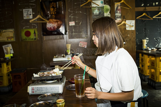 女人在商店烹饪吃烤肉图片