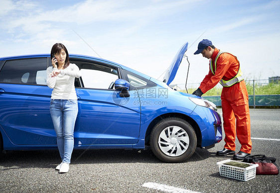 女子呼叫道路车辆救援服务人员检测修车图片