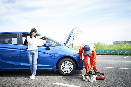 女子呼叫道路车辆救援服务人员检测修车图片