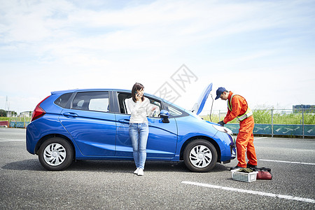 女子呼叫道路车辆救援服务人员检测修车图片