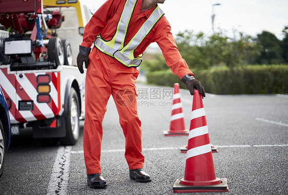 搬运桶锥放置路障的道路救援服务人员图片