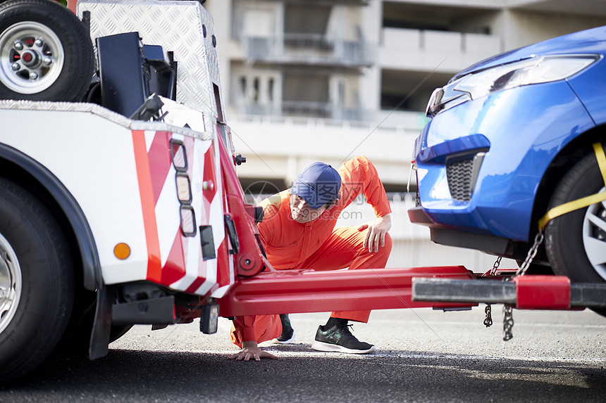 道路救援服务人员牵引故障车辆图片