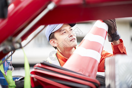 搬运桶锥放置路障的道路救援服务人员图片