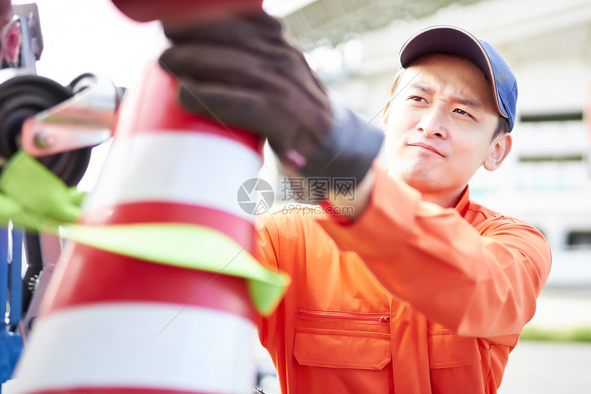 搬运放置路障锥桶的道路救援服务人员图片