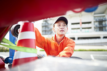 搬运放置路障锥桶的道路救援服务人员图片