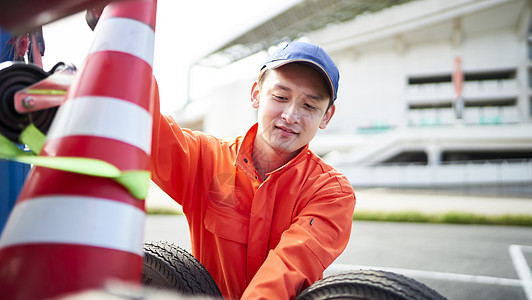 搬运放置路障锥桶的道路救援服务人员图片