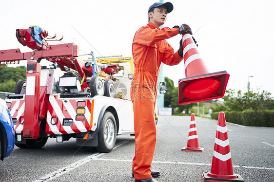 搬运放置路障锥桶的道路救援服务人员图片