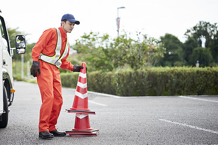 搬运放置路障锥桶的道路救援服务人员高清图片