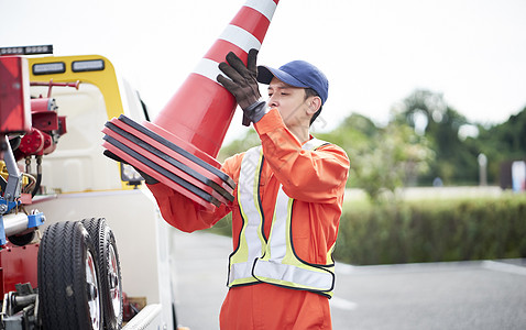 搬运放置路障锥桶的道路救援服务人员图片