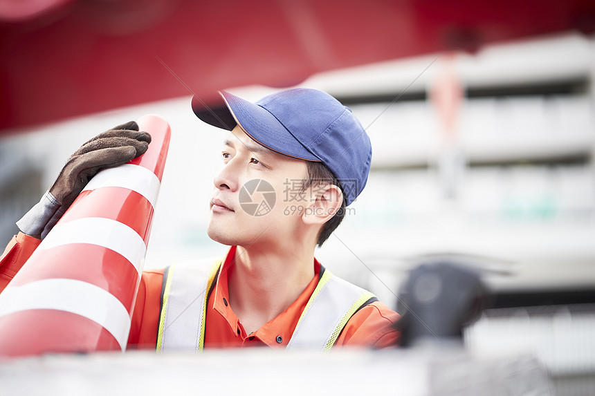 搬运路障锥桶的道路救援服务人员图片