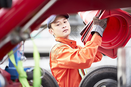 搬运路障锥桶的道路救援服务人员图片