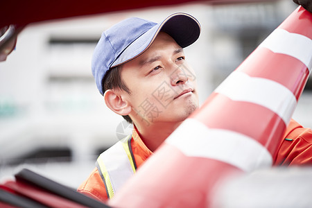 搬运路障锥桶的道路救援服务人员图片