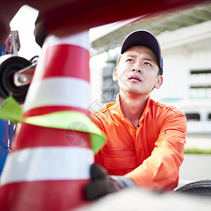 搬运路障锥桶的道路救援服务人员图片