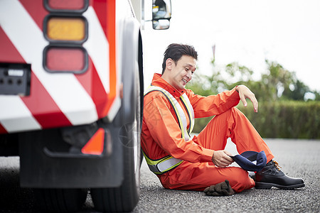 靠着车辆休息的道路救援服务人员图片