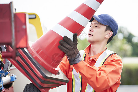 搬运路障锥桶的道路救援服务人员图片