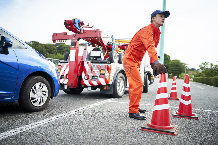 放置路障锥桶的道路救援服务人员图片