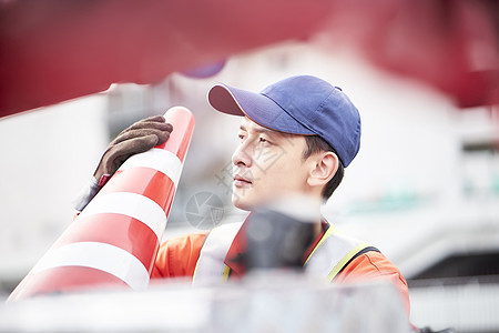 搬运路障锥桶的道路救援服务人员图片