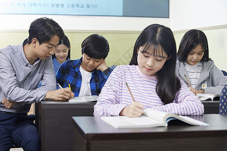 老师在教室里指导学生写作业图片