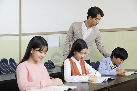 老师在教室里指导学生写作业图片