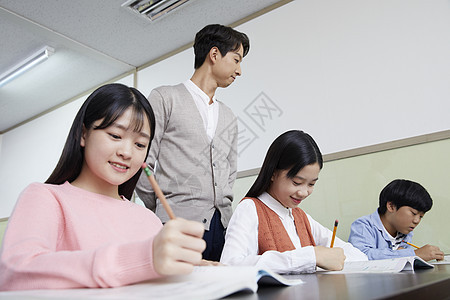 老师在教室里指导学生写作业图片