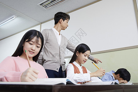 老师在教室里指导学生写作业图片