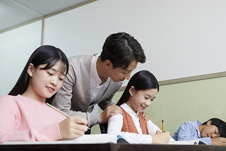 老师在教室里指导学生写作业图片