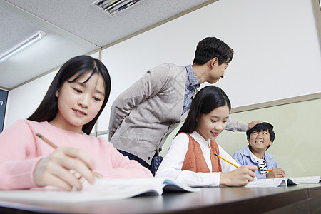 老师在教室里指导学生写作业图片