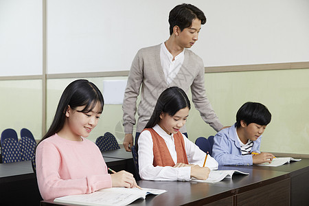 老师在教室里指导学生写作业图片