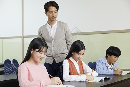 老师在教室里指导学生写作业图片