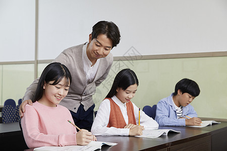 老师在教室里指导学生写作业图片