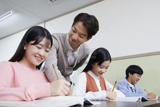 老师在教室里指导学生写作业图片