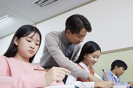 老师在教室里指导学生写作业图片