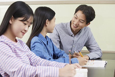 老师在教室里指导学生写作业图片