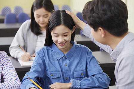 老师在教室里指导学生写作业图片