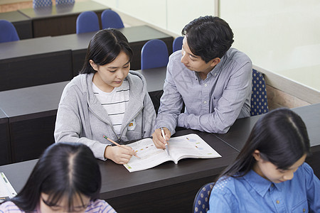 老师在教室里指导学生写作业图片