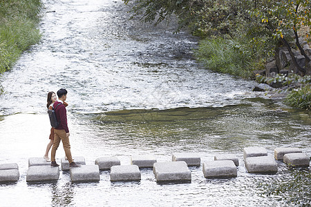 韩国植物年轻女子情人情侣约会溪流踏脚石图片