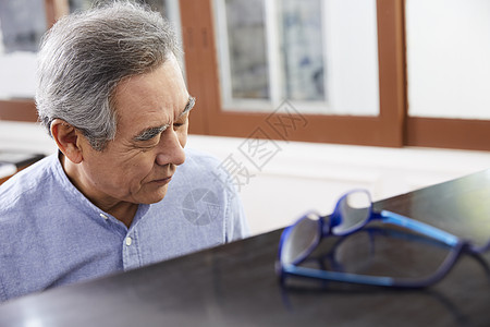 住房内摘掉眼镜的老人弹钢琴图片