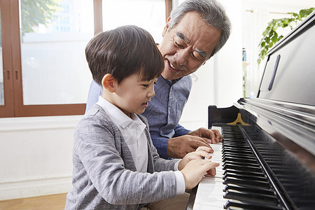 快乐祖父孙子一起弹钢琴图片