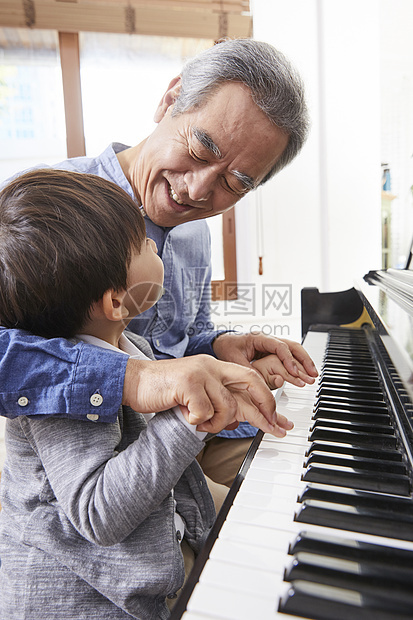 快乐祖父孙子一起弹钢琴图片
